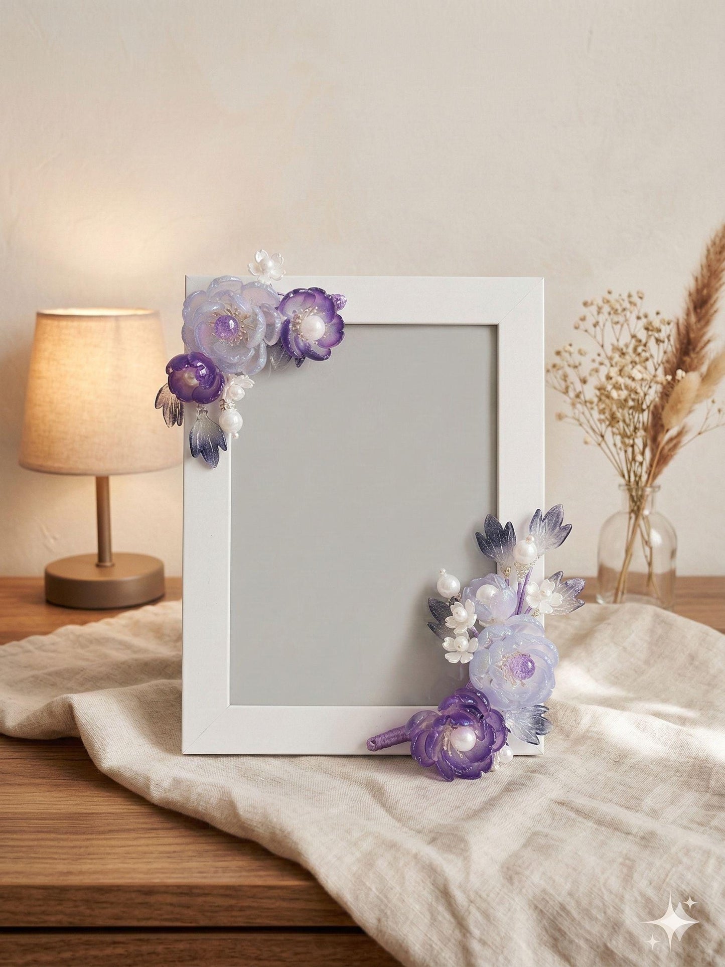 White frame with purple and white glass flowers at the corners