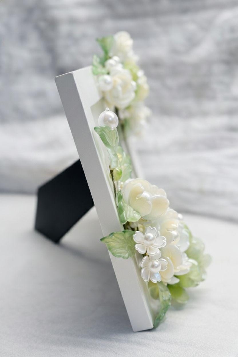 Glass floral frame displayed on a stand