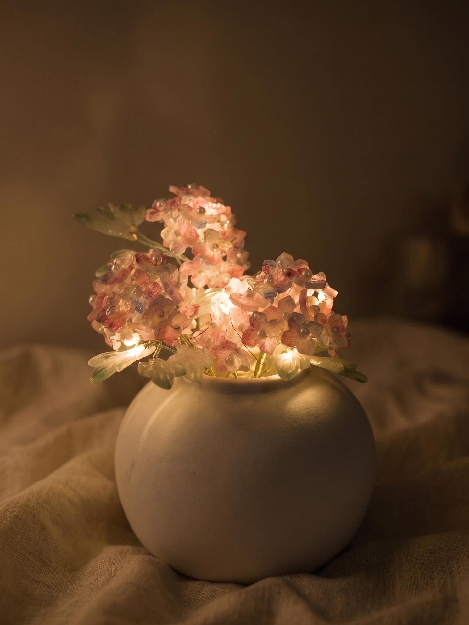 Pink hydrangea glass vase glowing with warm LED lights