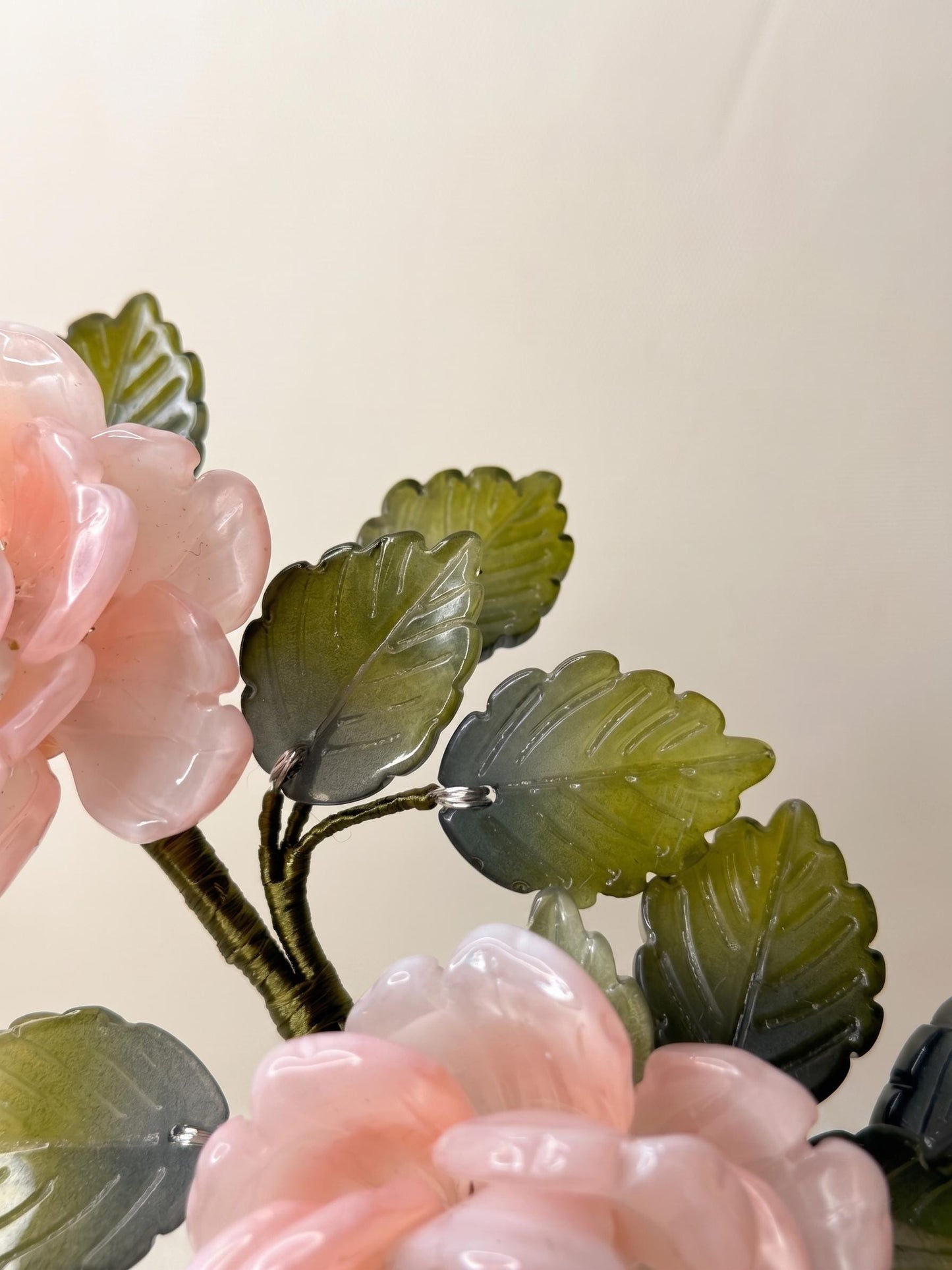 Detail of pink glass rose petals and green leaves