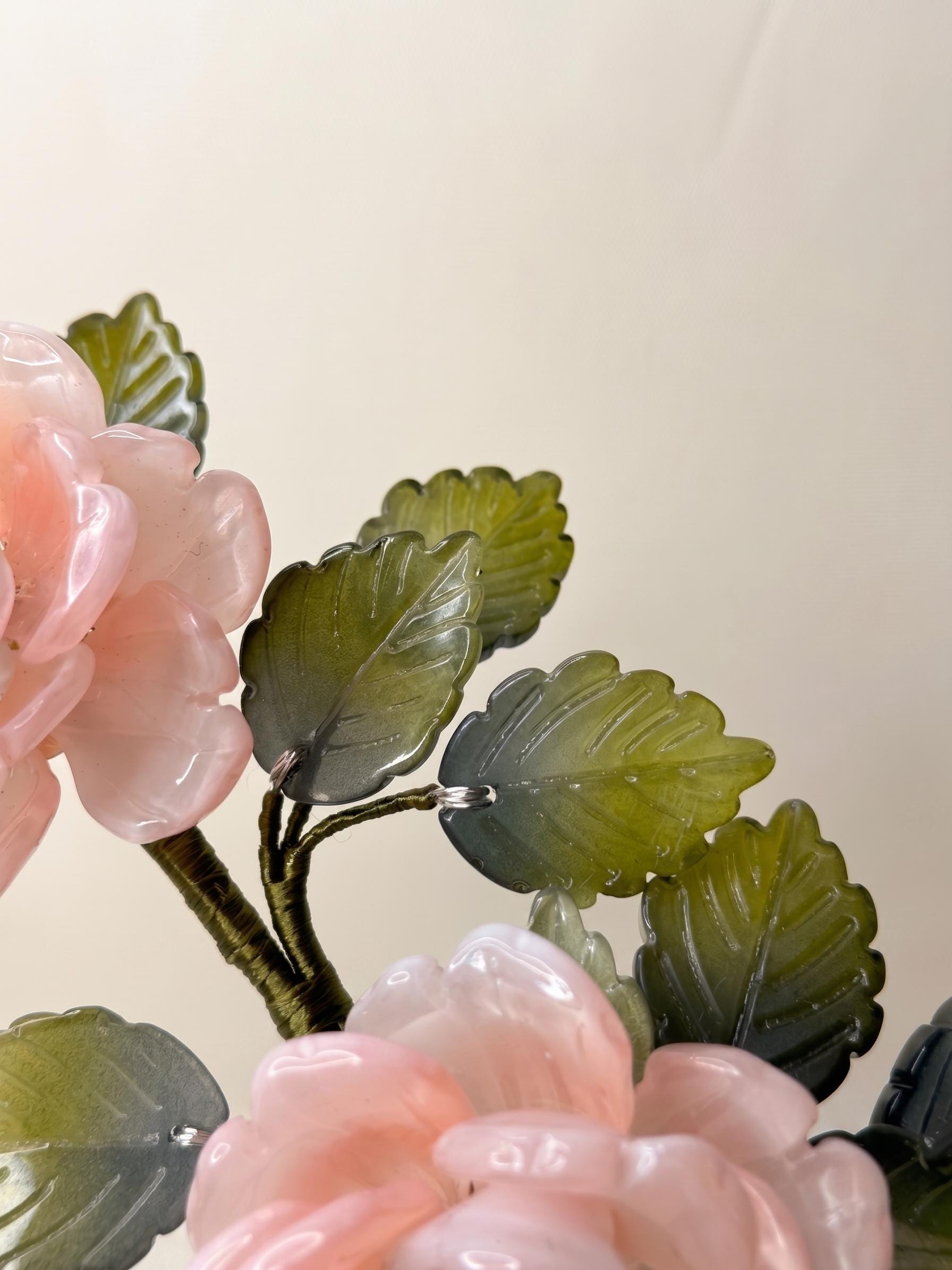 Detail of pink glass rose petals and green leaves
