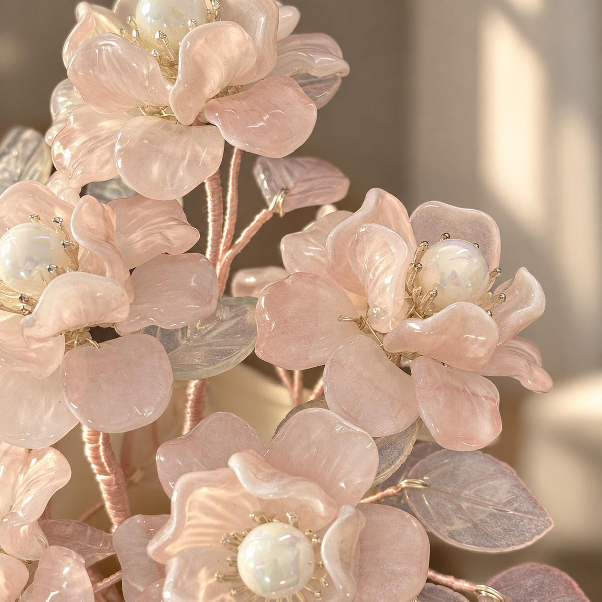 Warm LED lights draped through the pink glass camellias at night