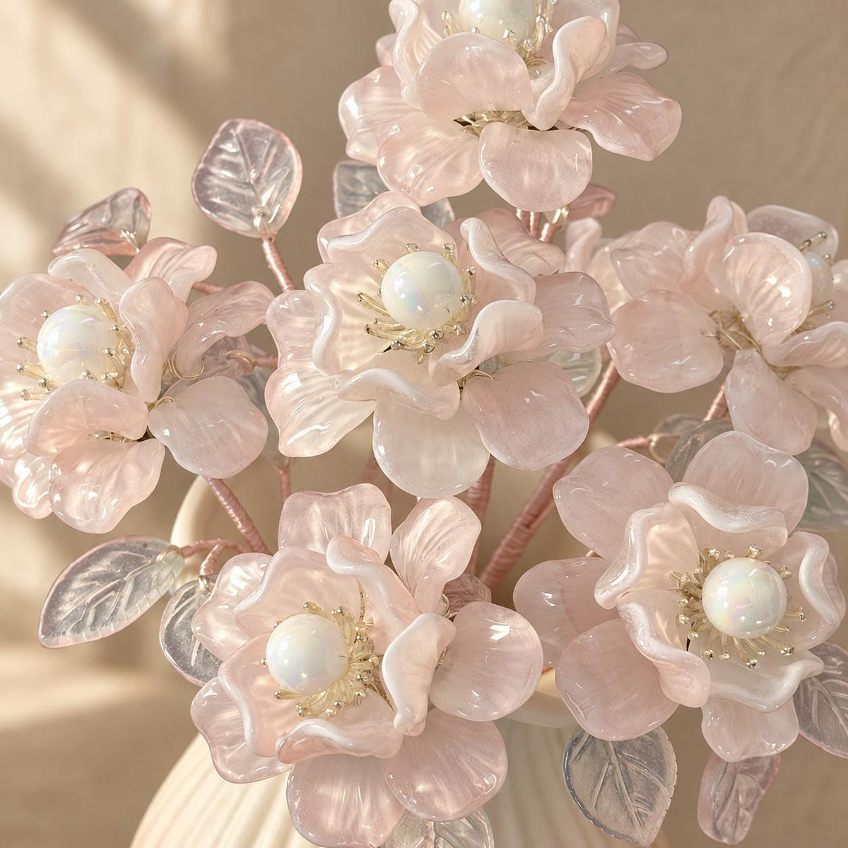 Translucent glass leaves draping over the ribbed vase rim