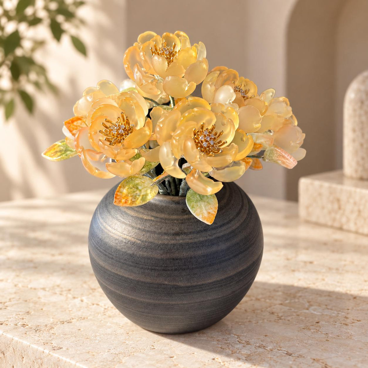 Pale amber glass peony arrangement in dark round ceramic vase